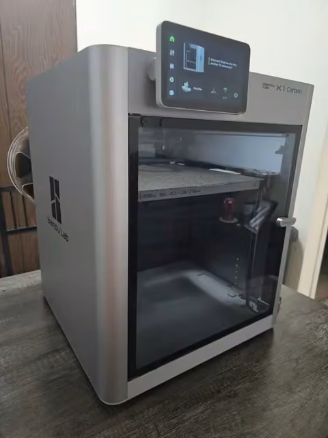 Bambu Lab X1-Carbon 3D printer with its touchscreen display showing the print menu